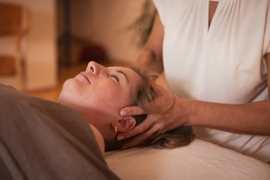 Eine Teilnehmerin gibt eine Nacken- und Kopfmassage