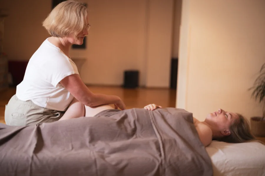Eine Trainerin arbeitet an der Massageliege